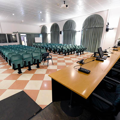 sala conferenza con pavimento a scacchi color pesca e beige e sedie verdi