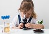 Bambina che guarda attraverso un microscopio