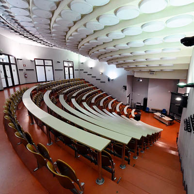 lecture theatre seen from above with rows of desks and red floor