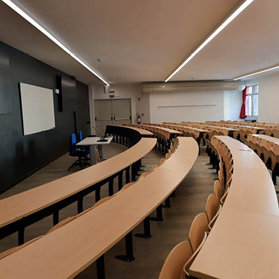 lecture theatre with wooden desks and seats arranged in curved rows