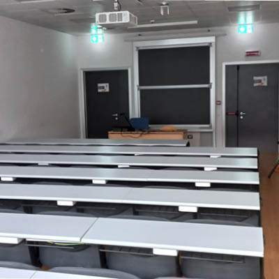 classroom with white desks, chairs and blackboard