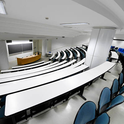 lecture theatre with white desks and blue chairs