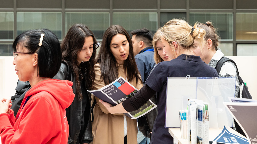 gruppo di ragazze che consulta una brochure