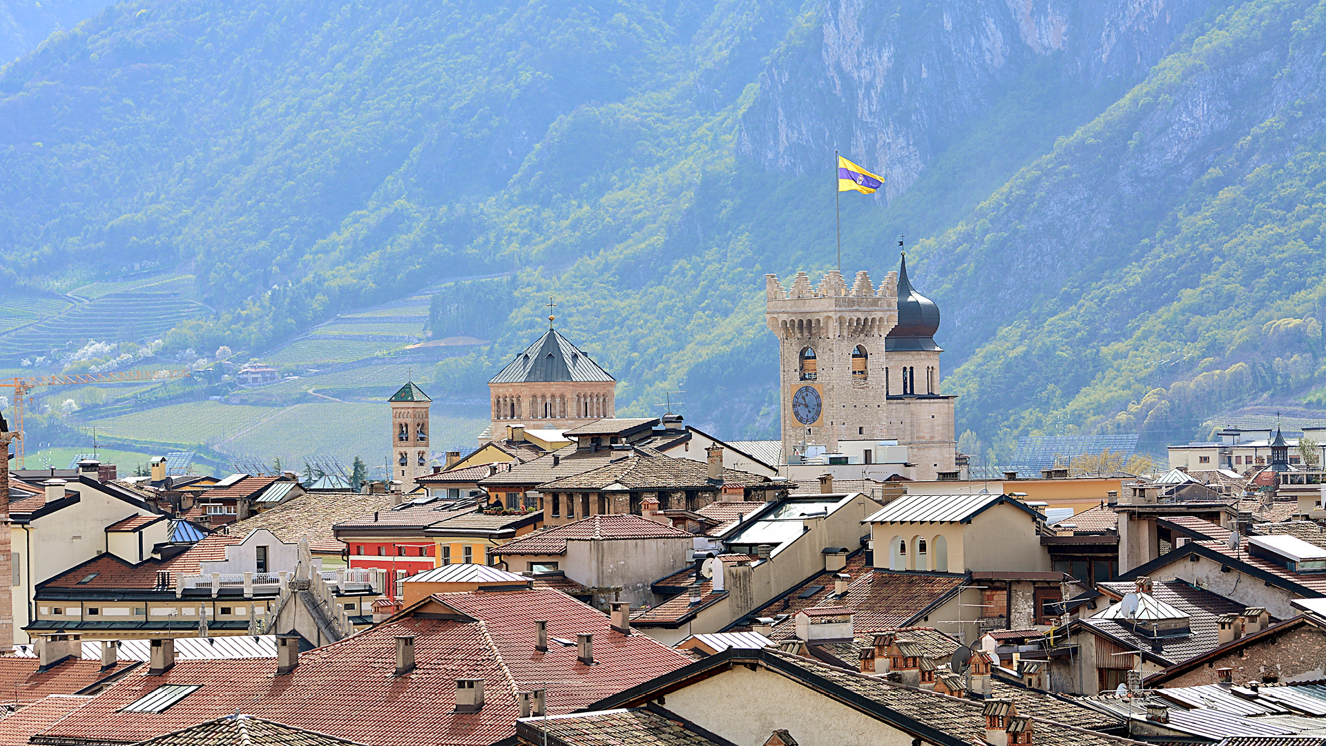 vista tetti città di trento con torre e bandiera