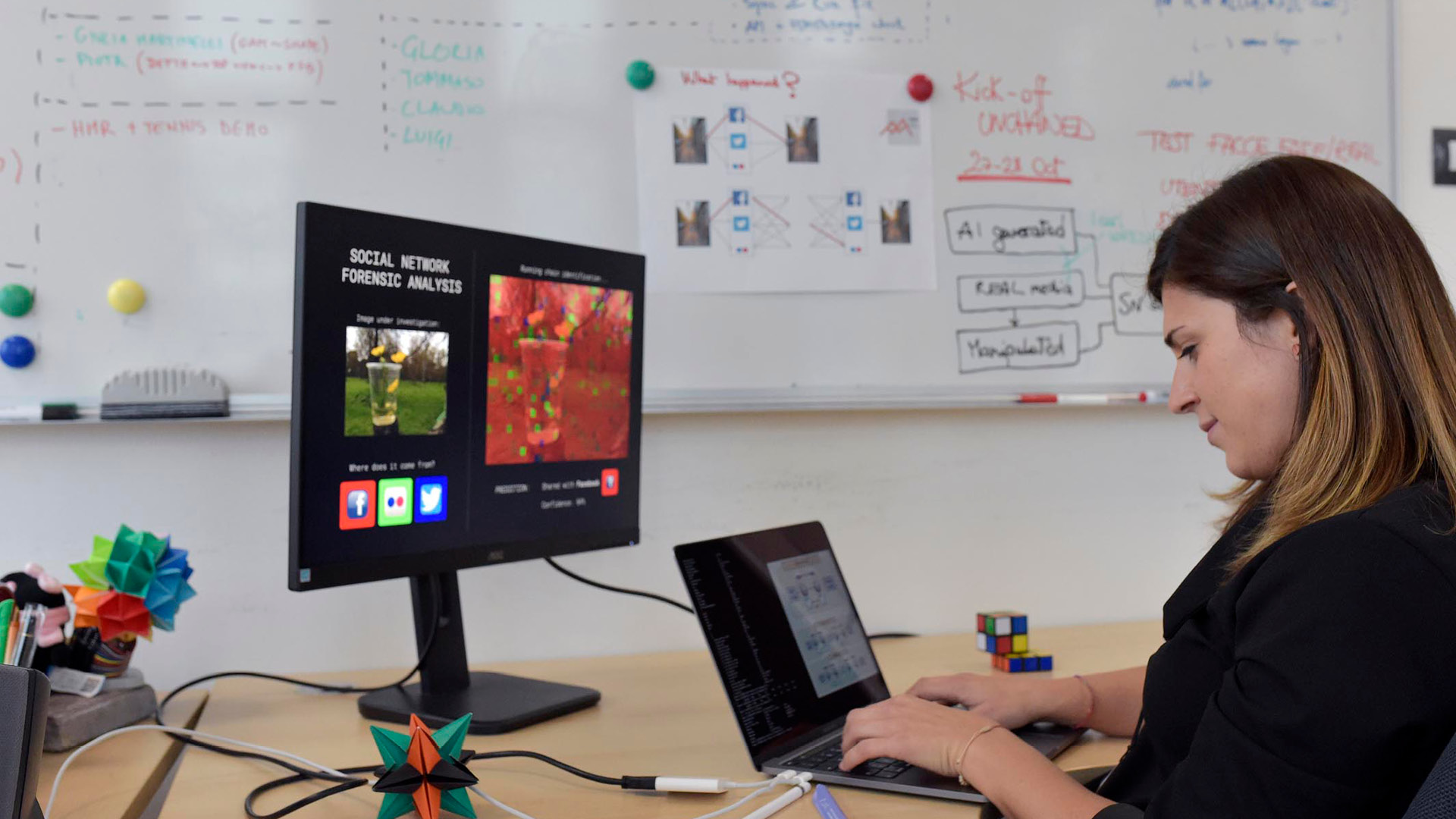ricercatrice al lavoro al computer con lavagna sullo sfondo