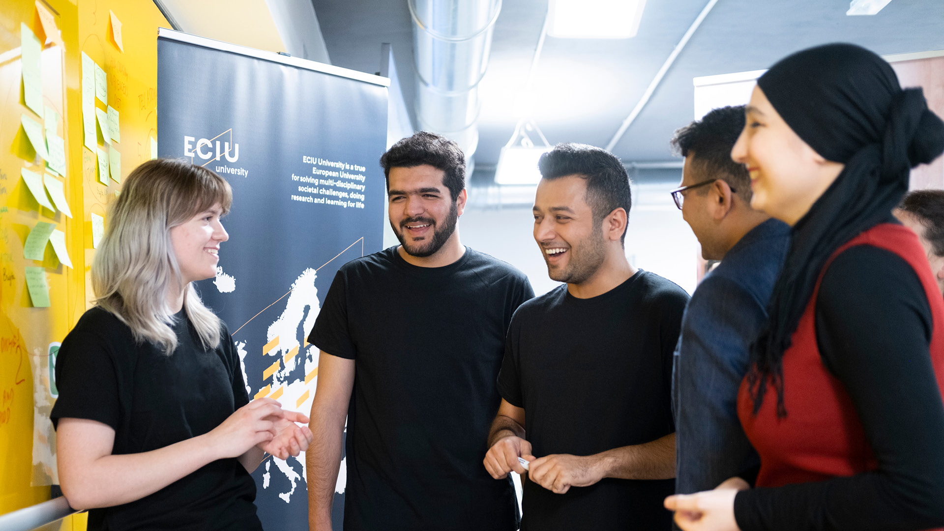 gruppo di ragazzi che collaborano poster di ECIU university sullo sfondo