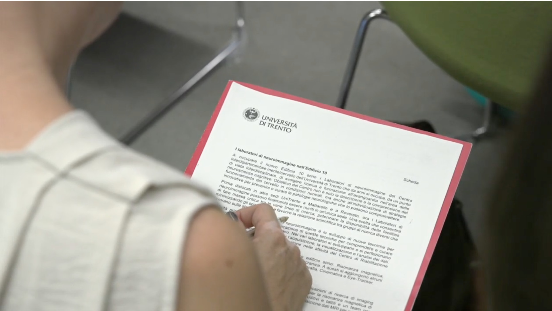 Persona di spalle con documento intestato Università di Trento