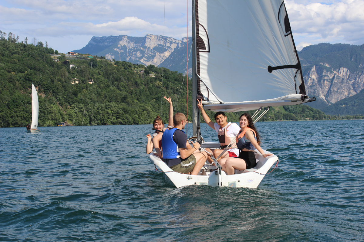 Ragazzi su barca a vela che salutano