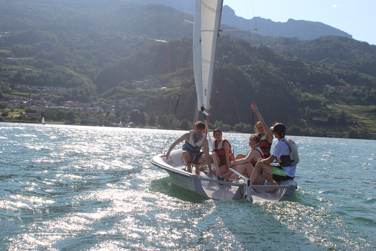 Ragazzi su barca a vela che salutano