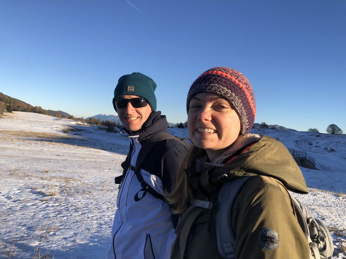 Uomo e donna che sorridono in vestiti invernali sulla neve del Monte Bondone