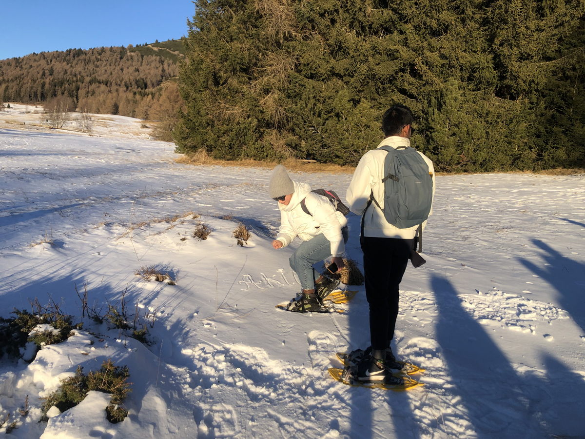 Uomo e donna che osservano la neve sul Monte Bondone
