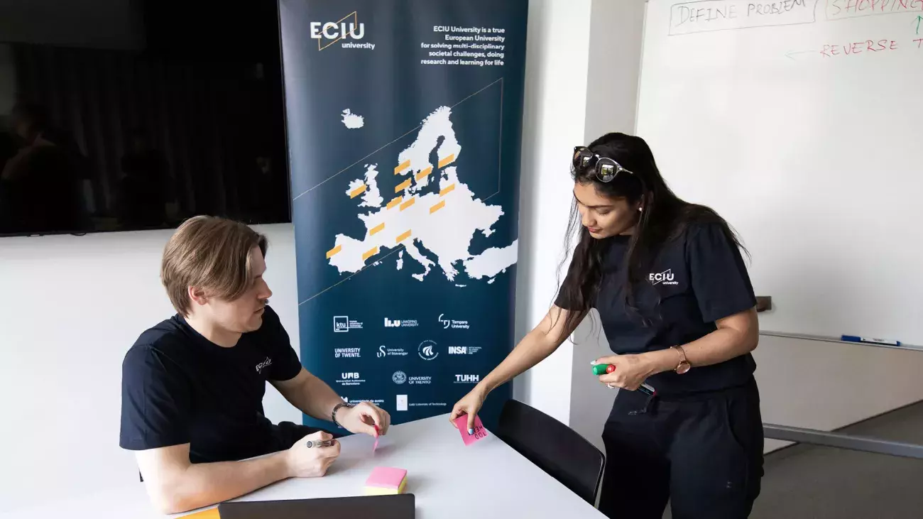 ragazzi con poster eciu university alle spalle