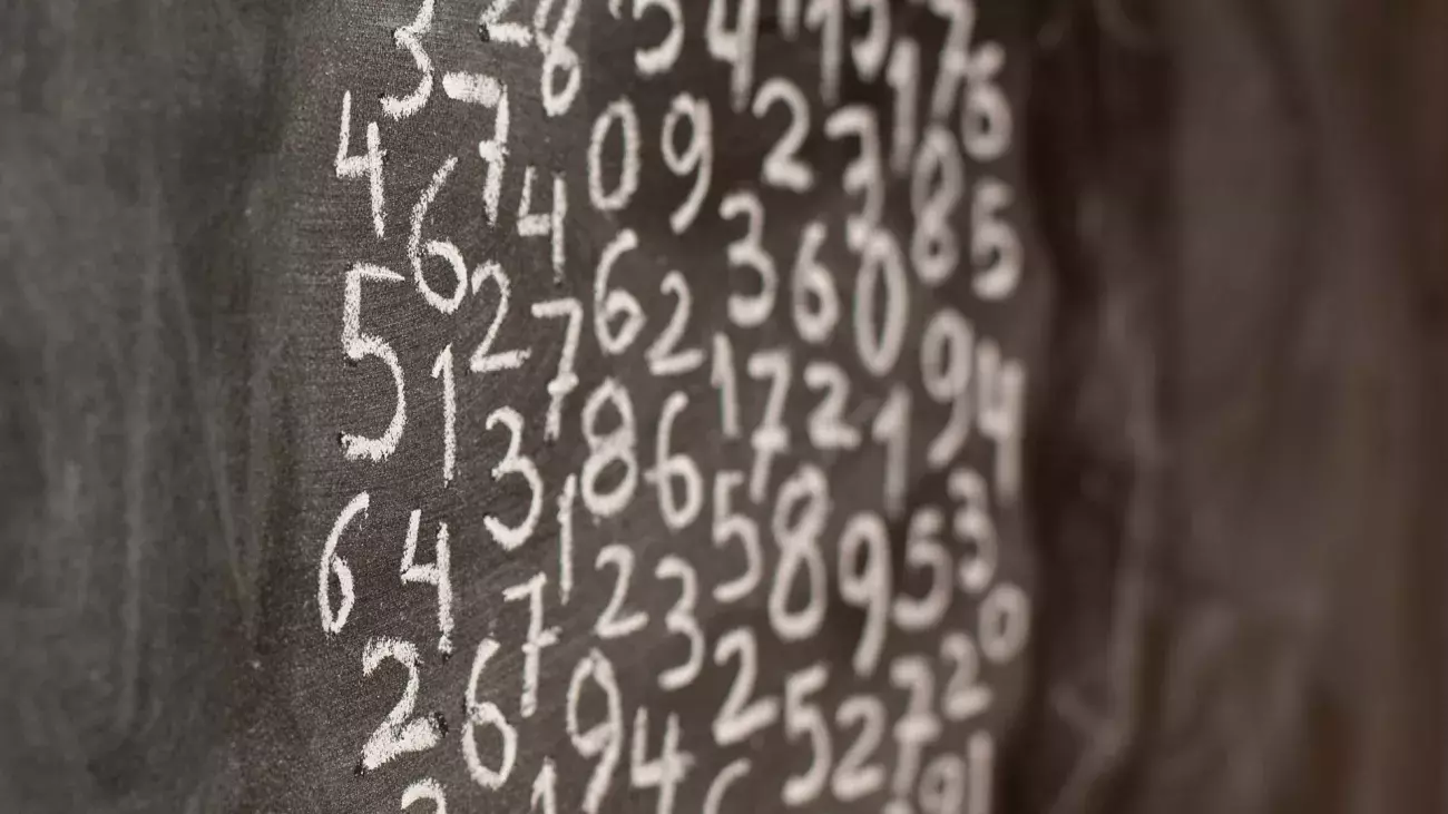 lavagna scura con numeri scritti con gesso bianco raggruppati in un insieme circolare