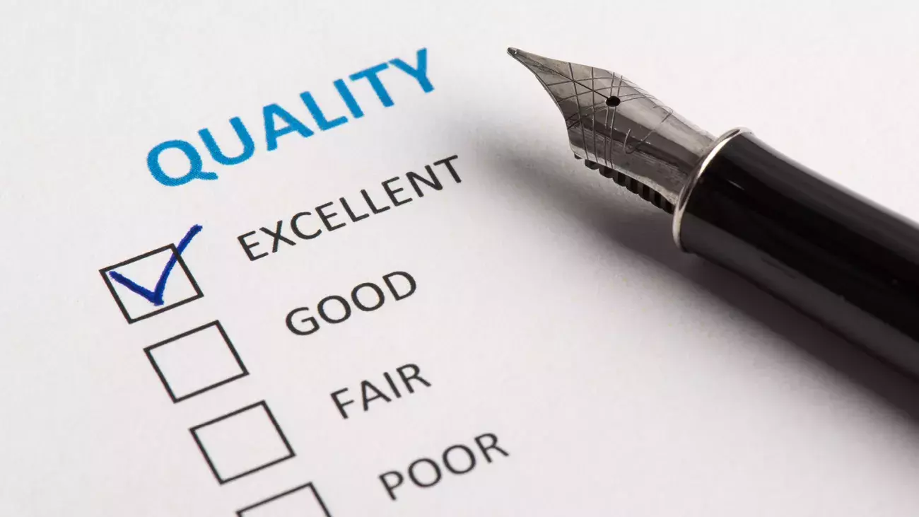 penna stilografica e foglio con questionario di valutazione qualità, spunta su casella excellent