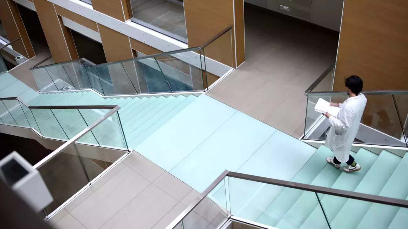 sede C3A, scalinata interna in vetro vista dall'alto con studente in camice