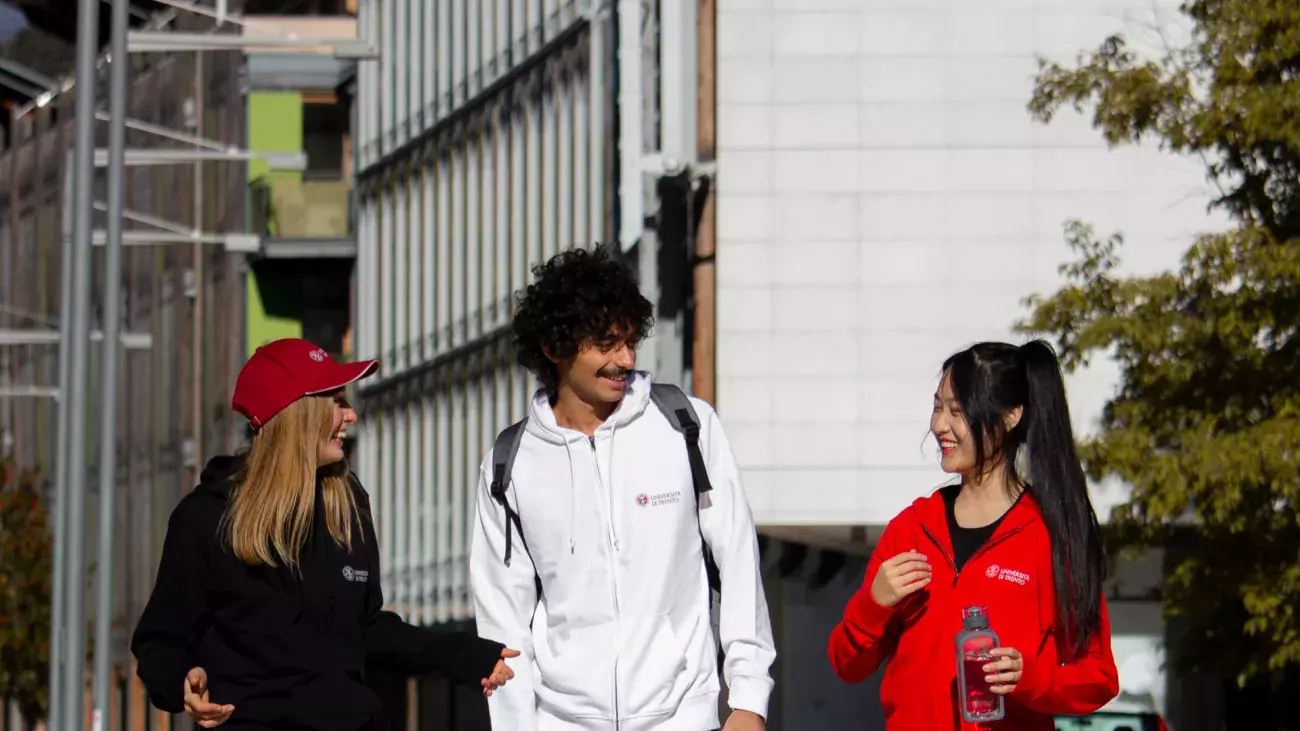 tre ragazzi internazionali vestiti con merchandising unitrento