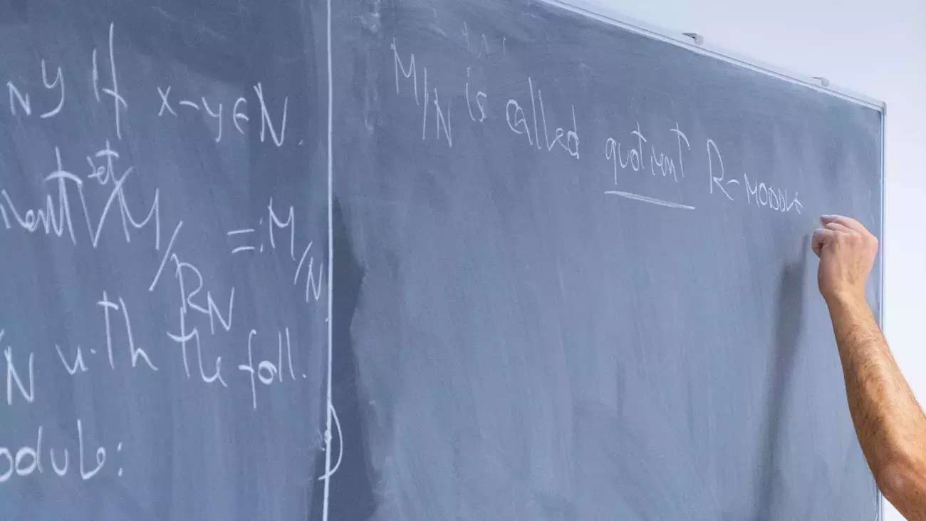 mano docente che scrive alla lavagna