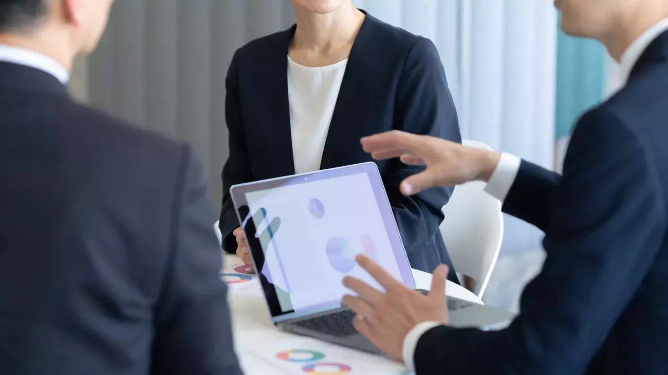 laptop con grafici particolare mani, gruppo di persone in sala riunioni