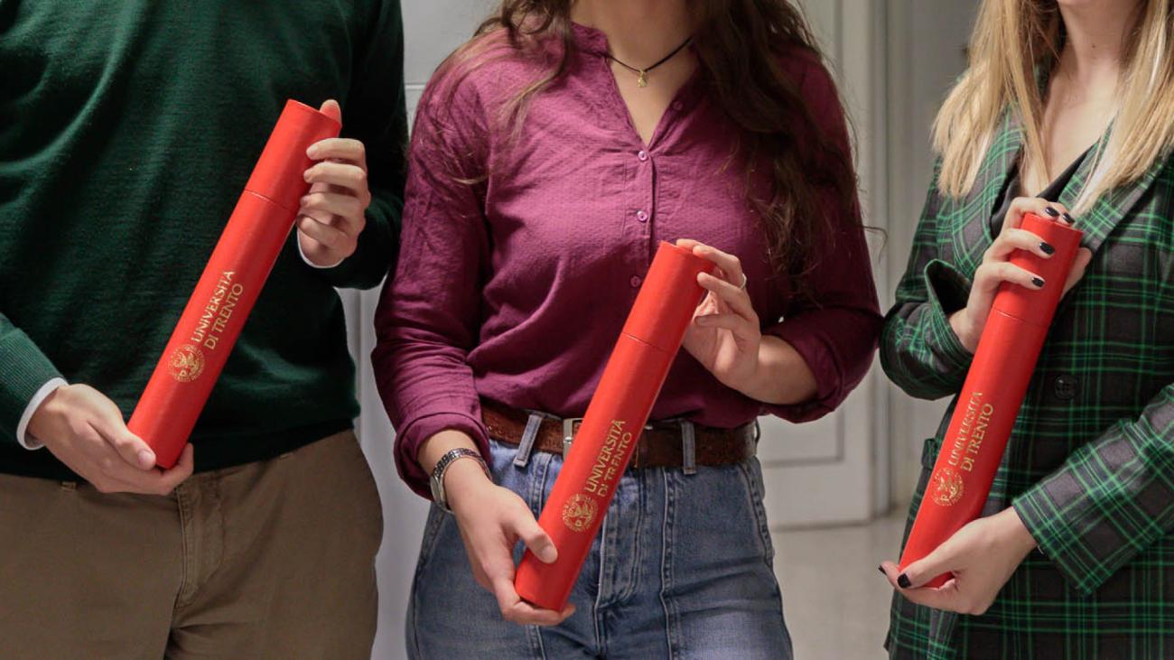 Pergamene premi di laurea, mani con tubi rossi