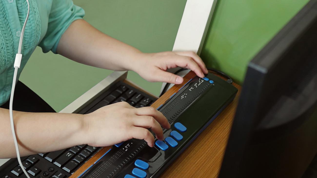 mani su tastiera con tecnologie assistive
