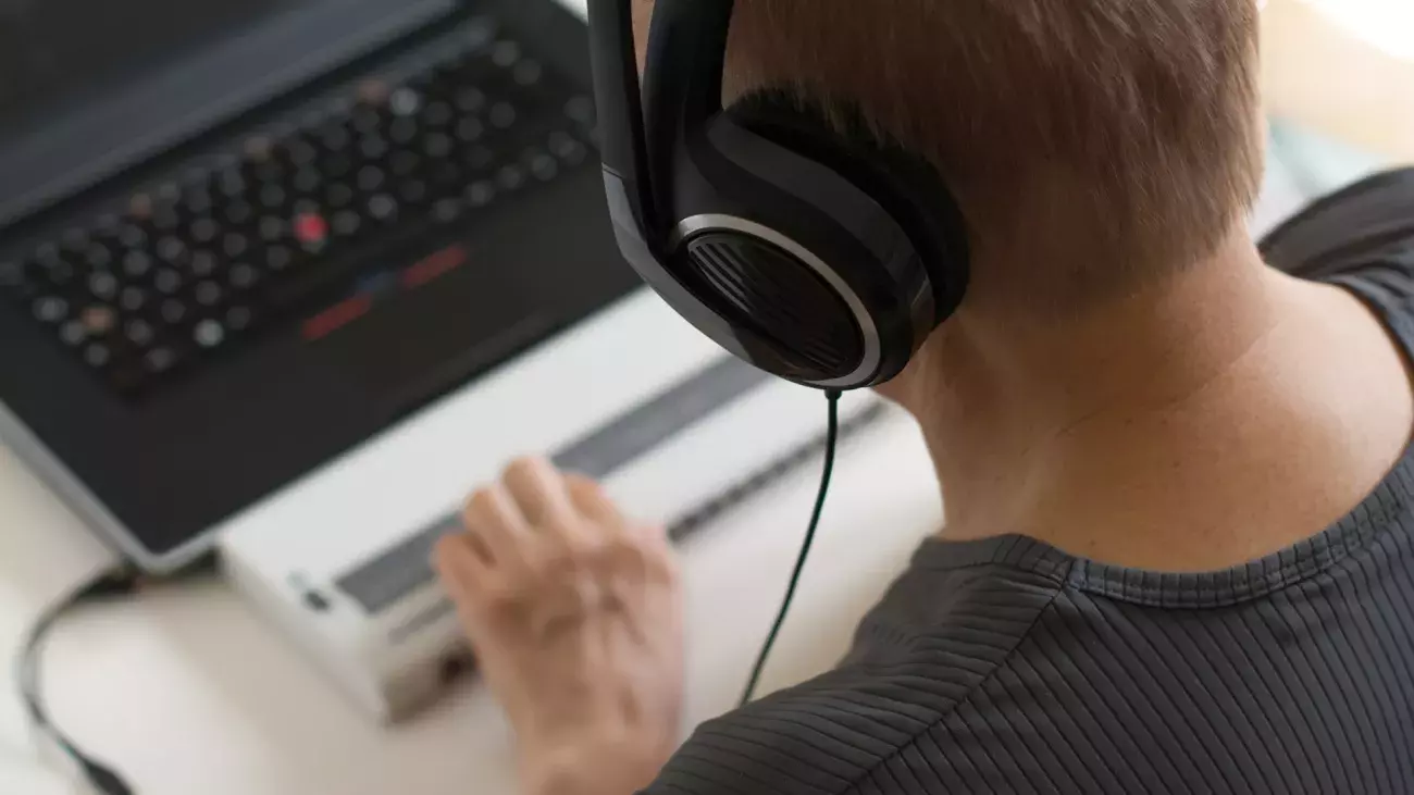 persona di spalle con laptop che utilizza tecnologie assistive