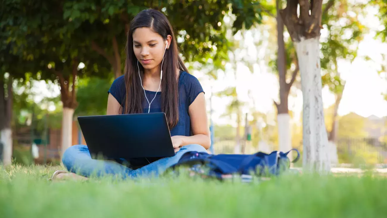 ragazza in un prato con laptop