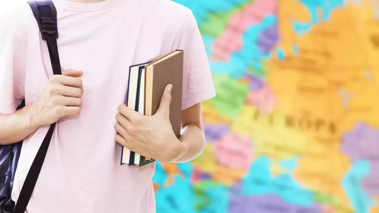 Studente con libri e zaino con il mappamondo in sfondo