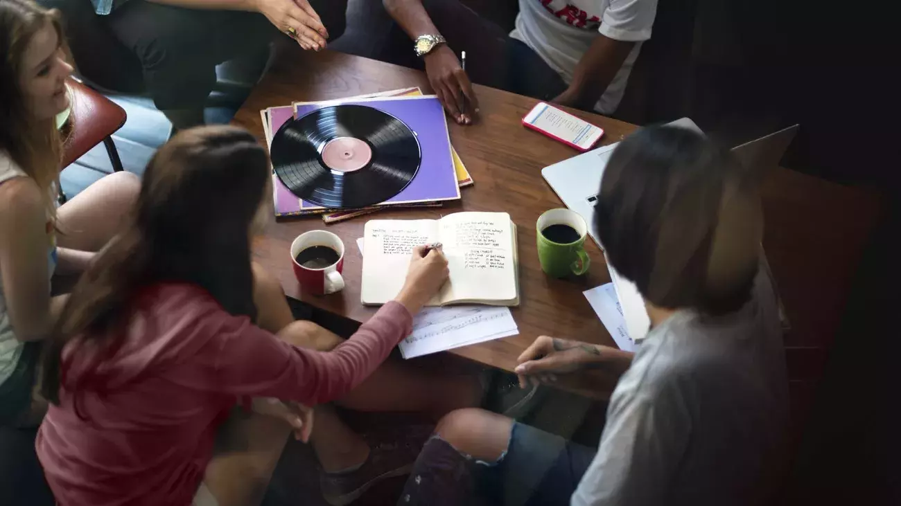 Ragazze e ragazzi intorno ad un tavolo che socializzano