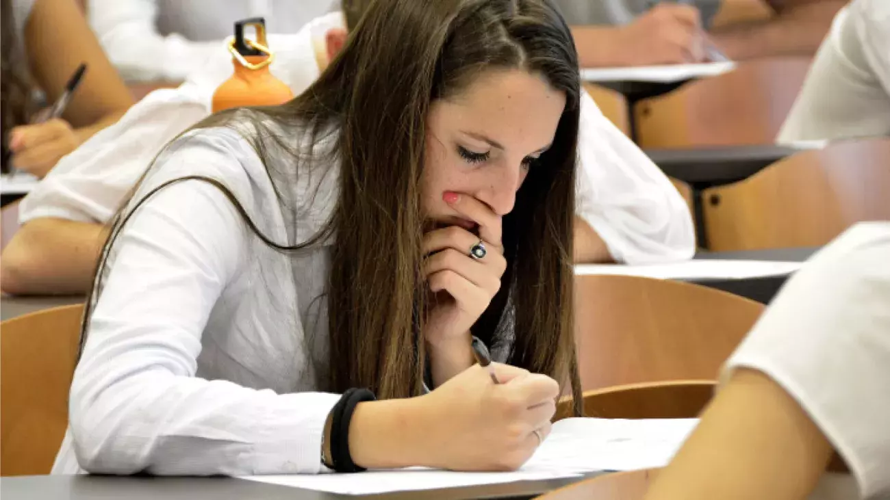 ragazza assorta con penna in mano durante test d'ingresso