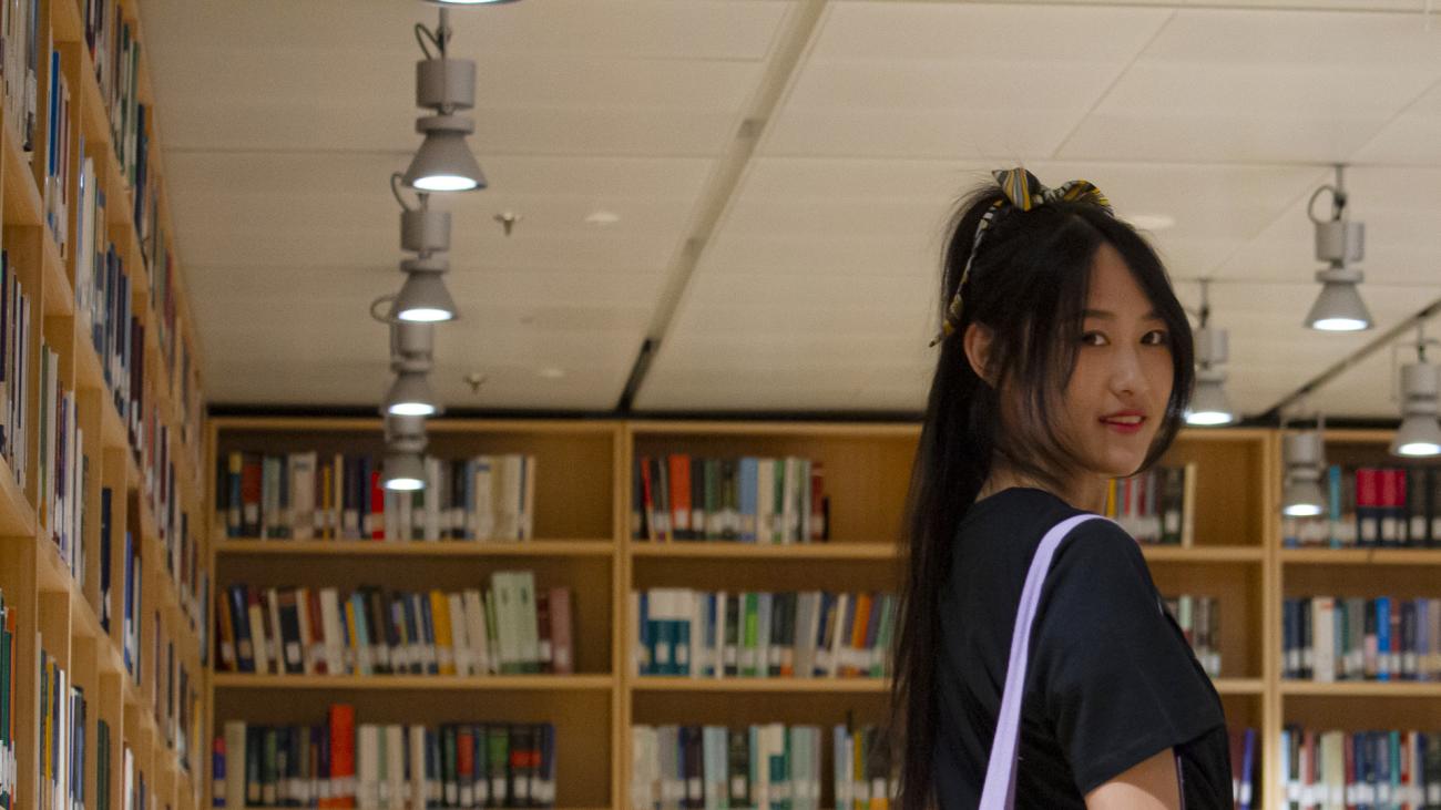 studentessa con lineamenti orientali in biblioteca