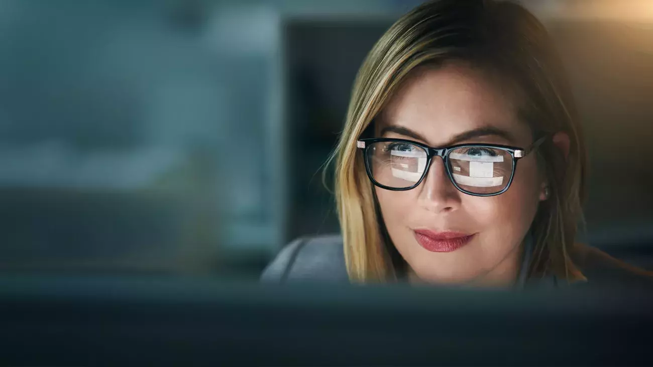 volto di donna con occhiali con riflesso di uno schermo nelle lenti