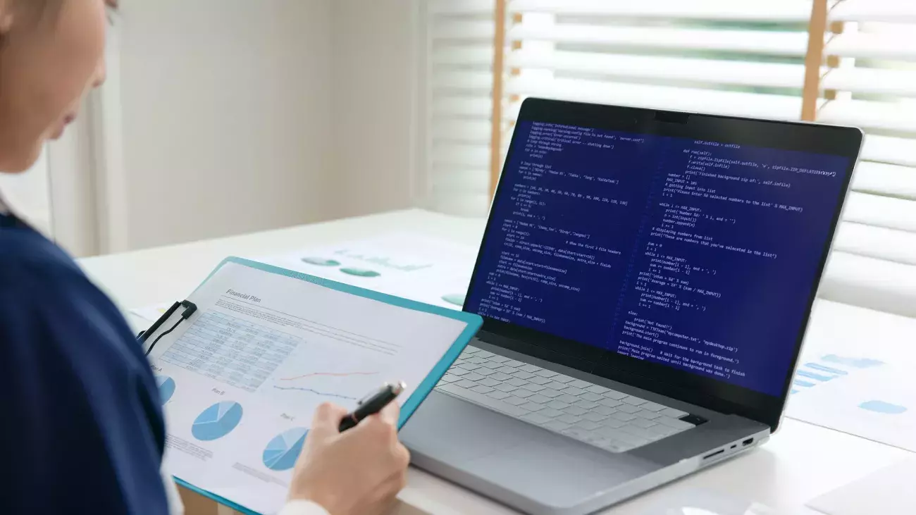 persona con foglio con dati grafici e computer